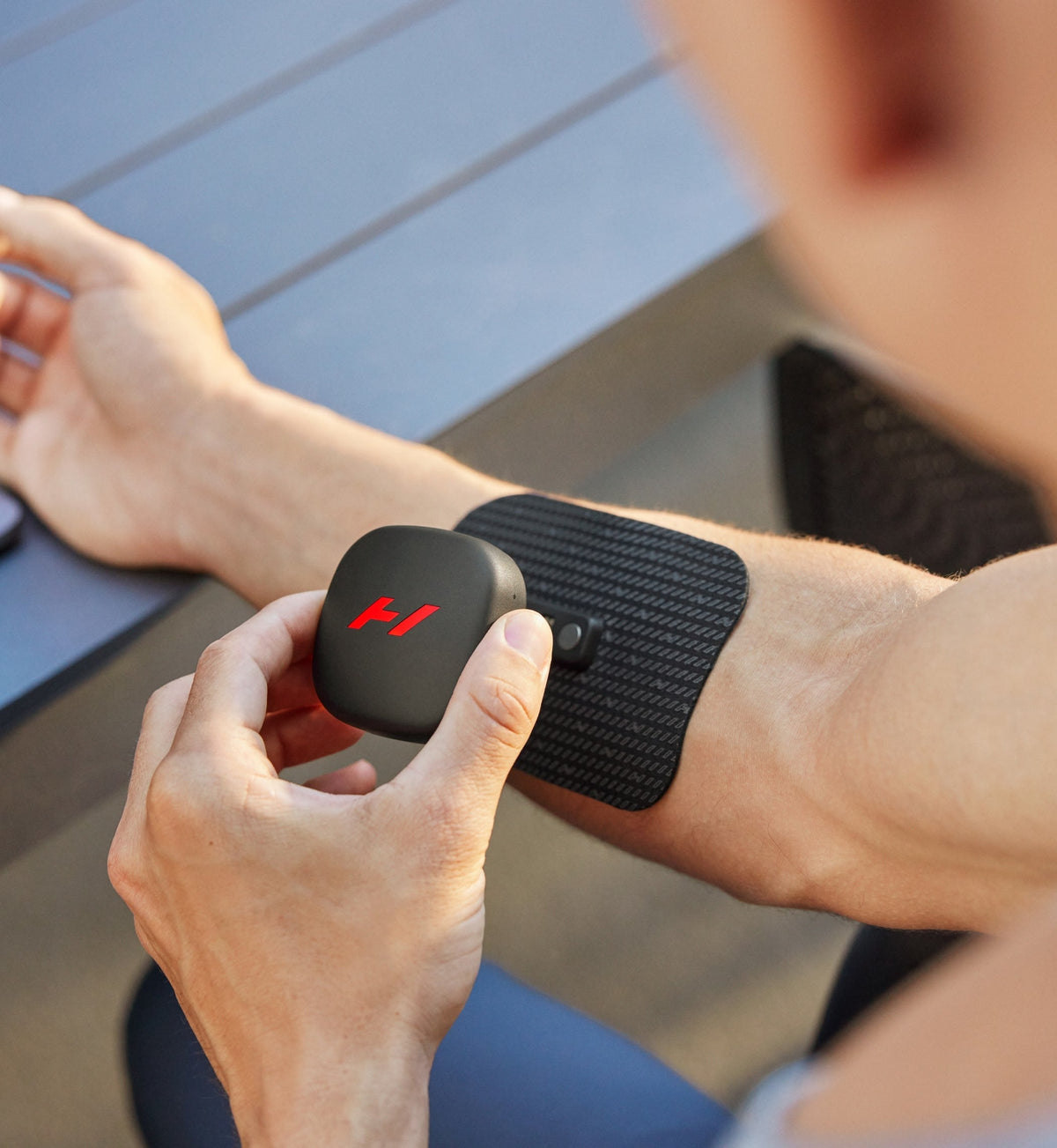 Person using a venom go device on their wrist with a blurred background